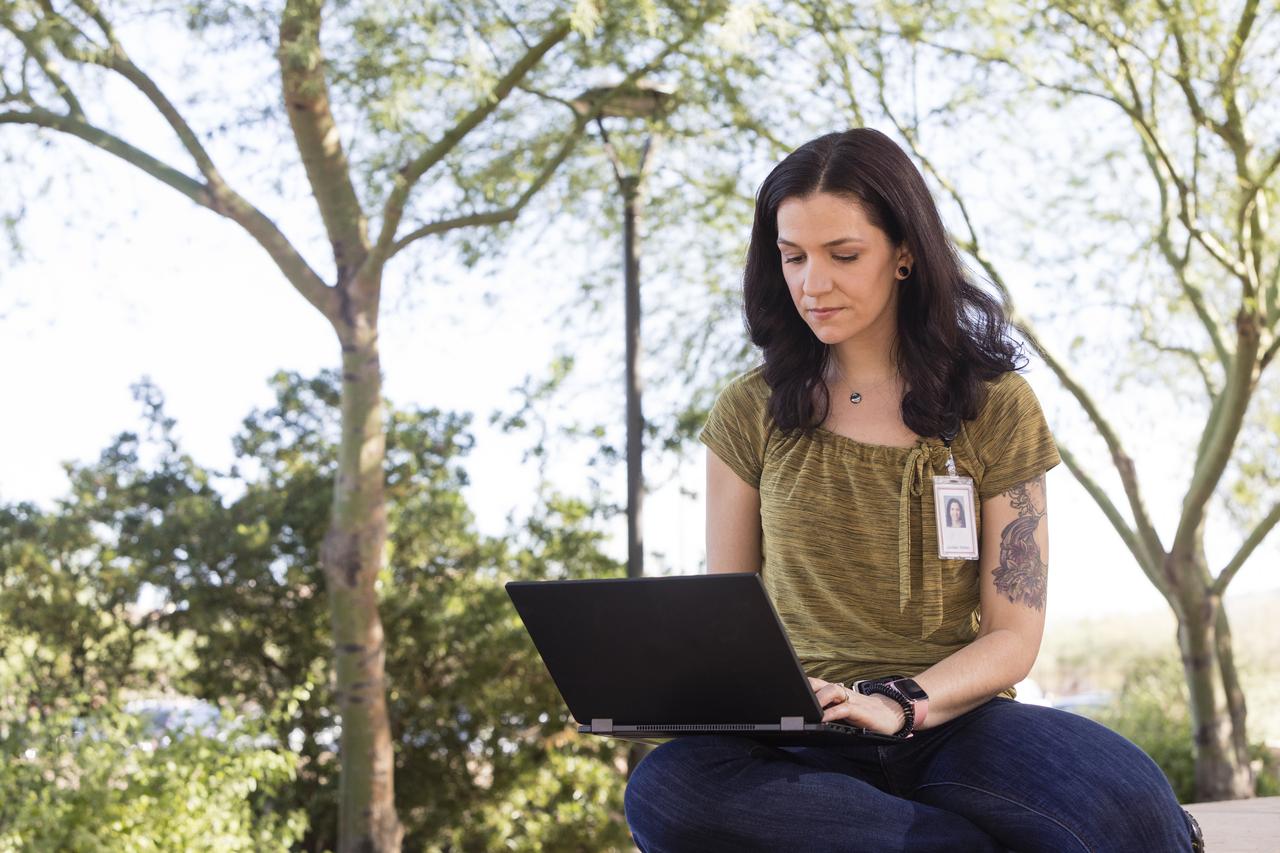 associate working on her laptop outside