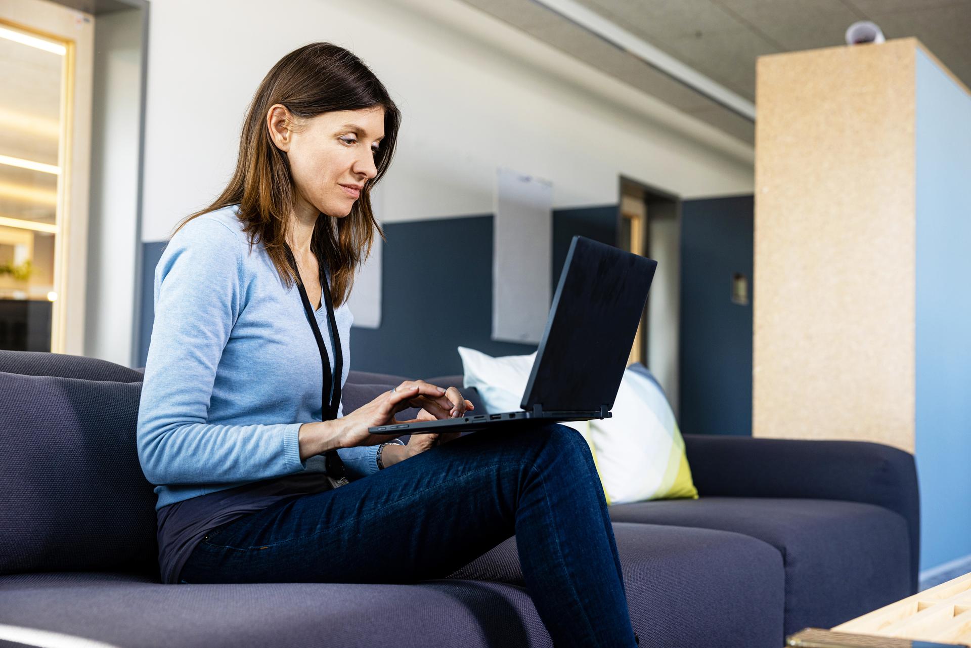 associate working on her laptop in an open office space