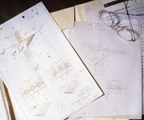 photo of original patents on a a desk with a pair of glasses