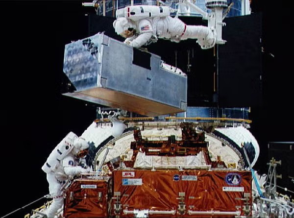 astronauts in space working on hubble telescope