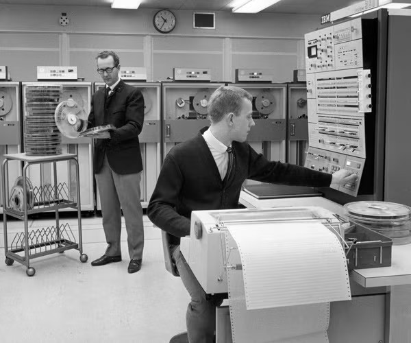 historical photo of men in larger computer room