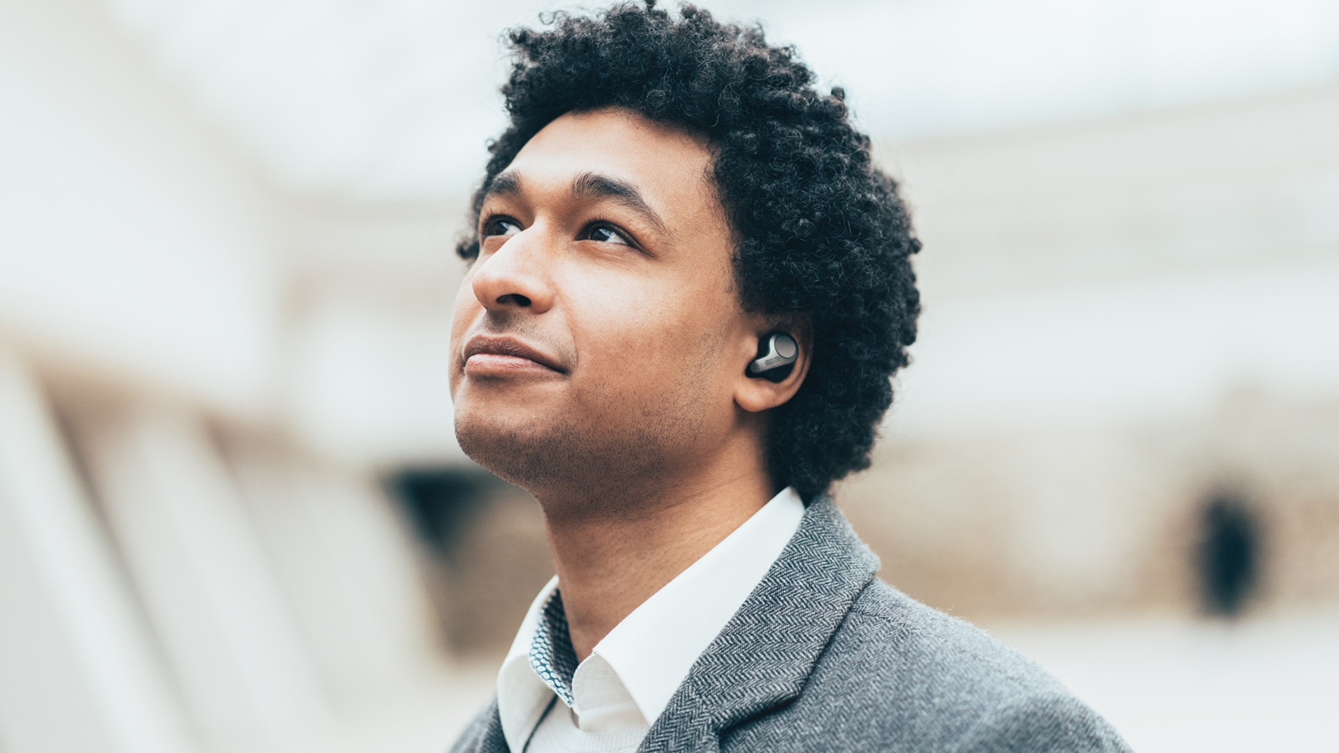 Young professional with earbuds in his ears