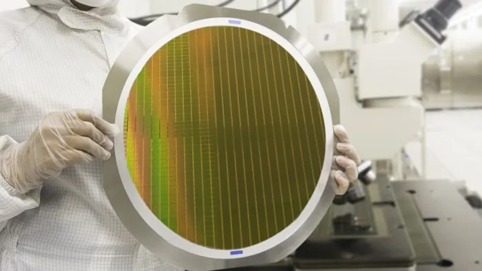 Worker holding a large electronic disc.
