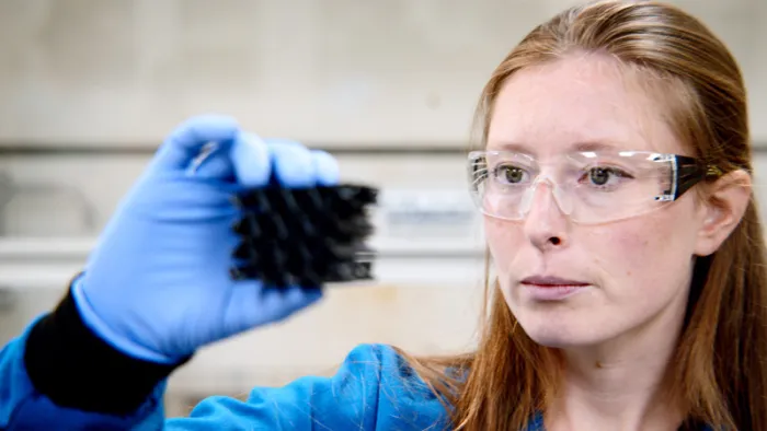 GORE Associate holding inspecting a product with PPE.