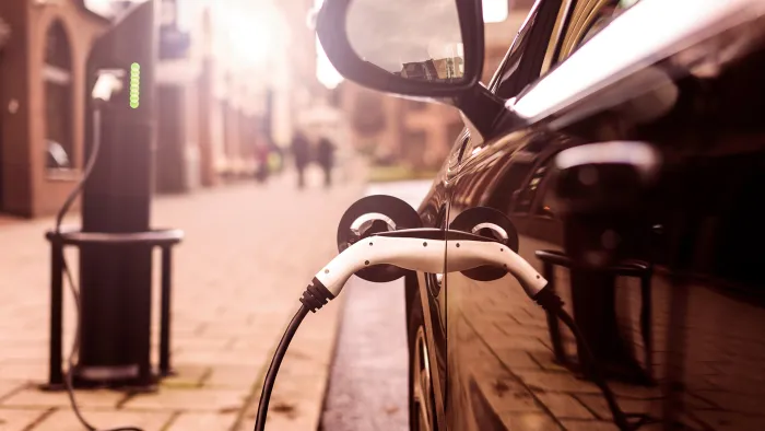 Electric Vehicle is charging in street.